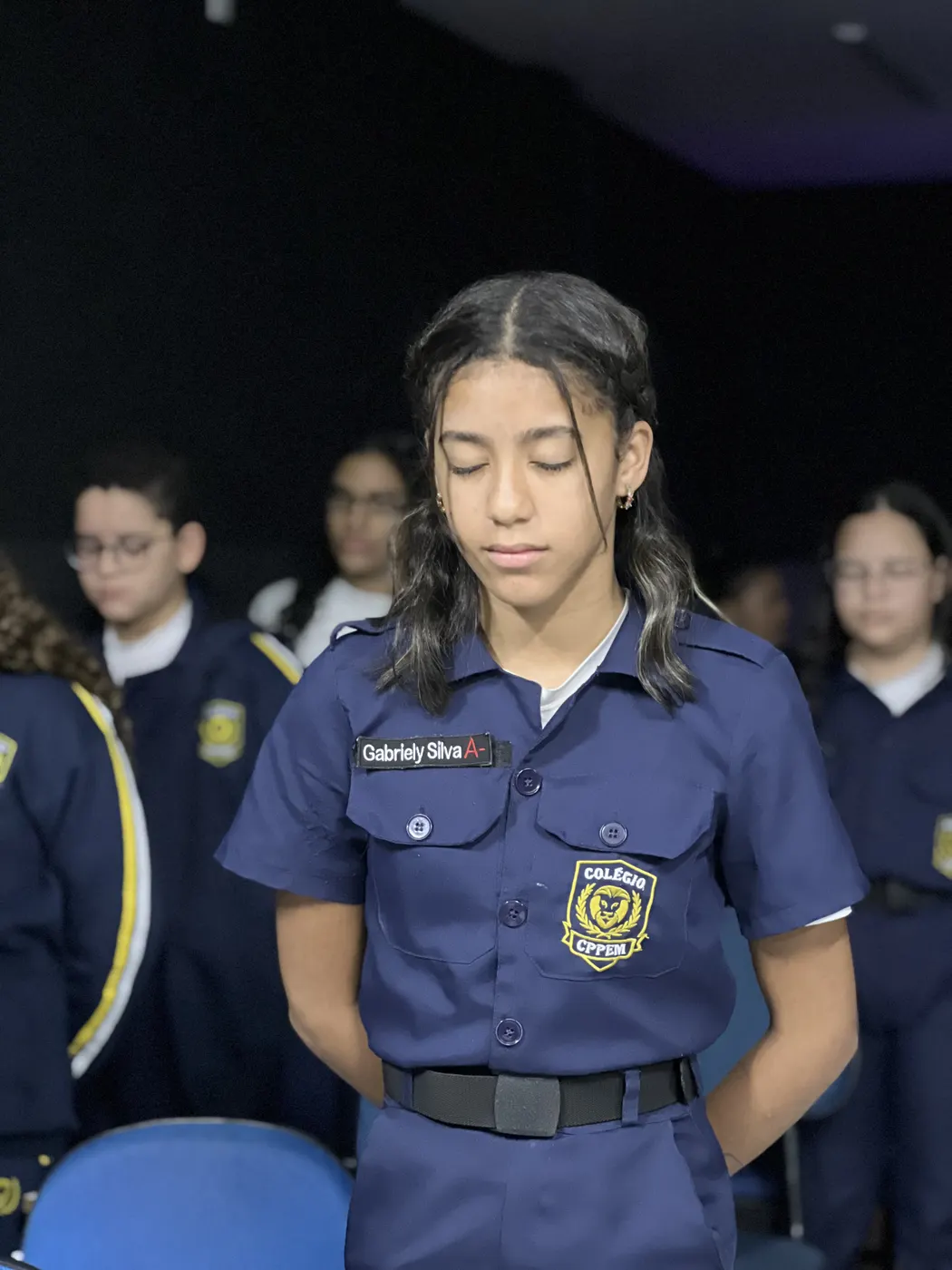 Aluna de olhos fechados durante a oração do devocional